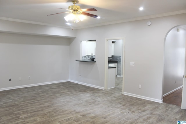 unfurnished living room featuring ornamental molding, ceiling fan, and hardwood / wood-style flooring