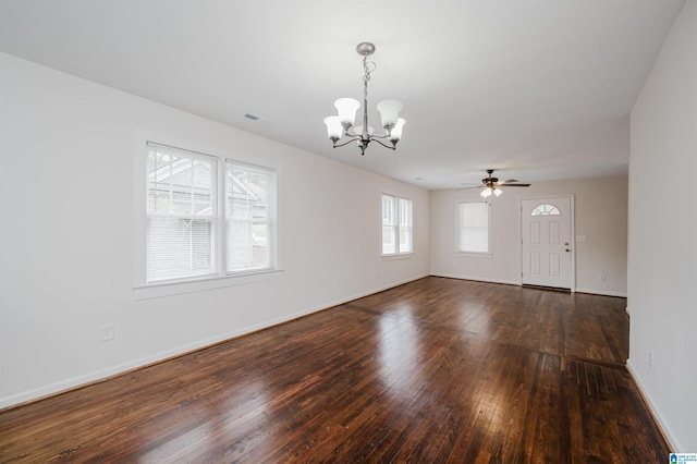 unfurnished room with ceiling fan with notable chandelier, dark hardwood / wood-style floors, and a healthy amount of sunlight