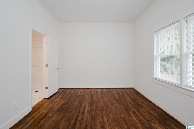 spare room with dark hardwood / wood-style flooring and a wealth of natural light