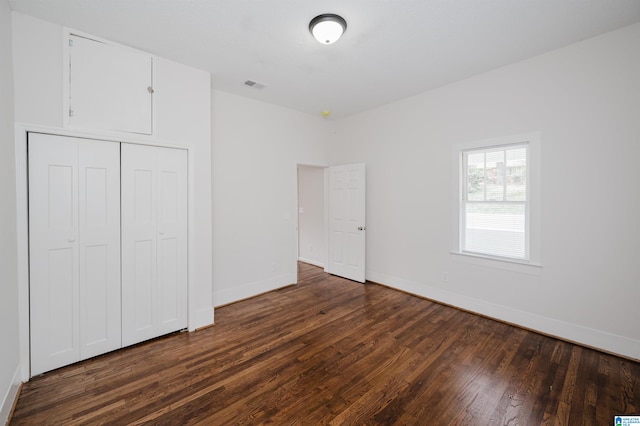 unfurnished bedroom featuring dark wood-type flooring and a closet