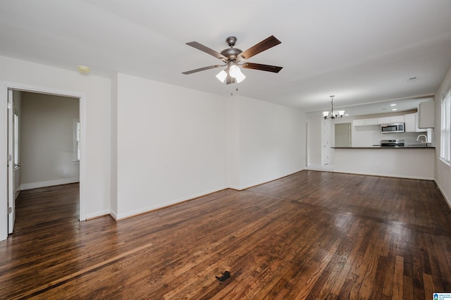 unfurnished living room featuring ceiling fan with notable chandelier, dark hardwood / wood-style floors, and sink