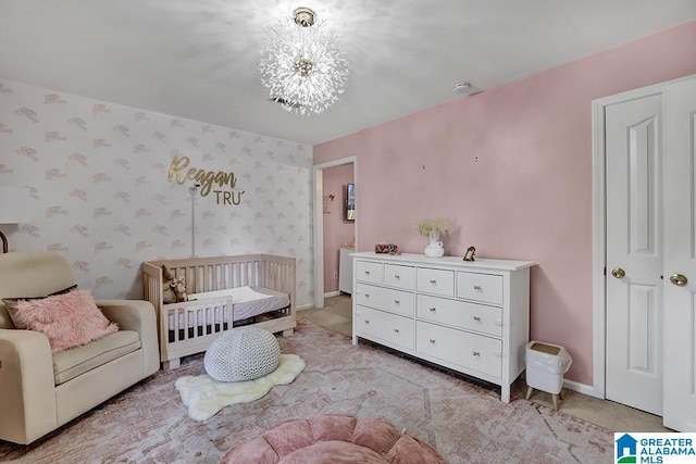 bedroom featuring a crib and a notable chandelier