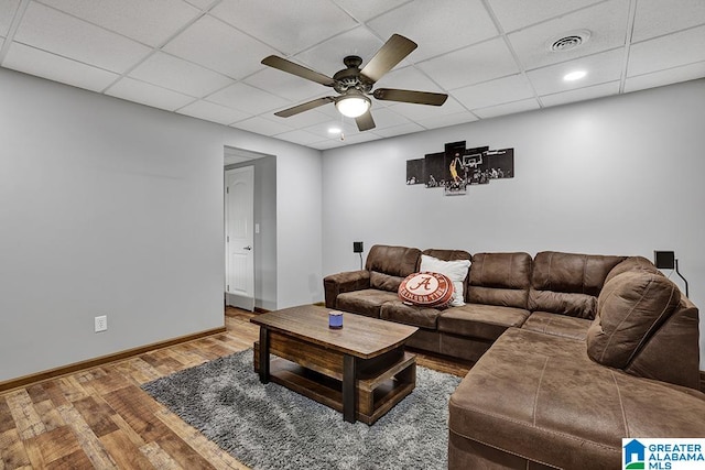 living room featuring a drop ceiling, ceiling fan, and hardwood / wood-style flooring