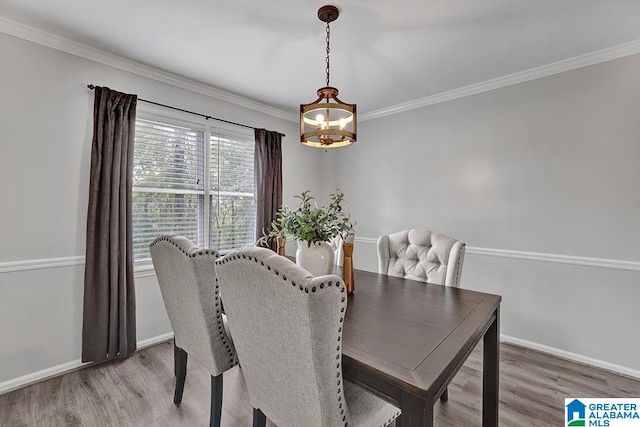 dining room with hardwood / wood-style flooring, crown molding, and a chandelier