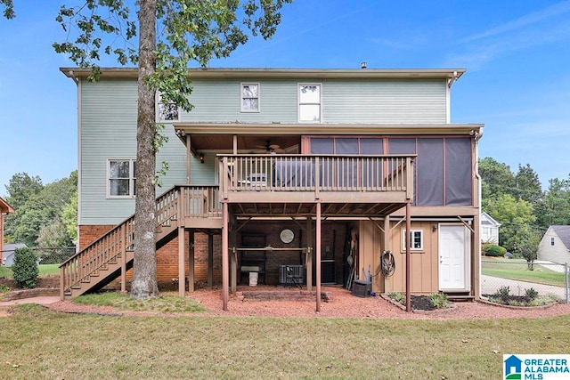 rear view of house with cooling unit, ceiling fan, a deck, and a yard