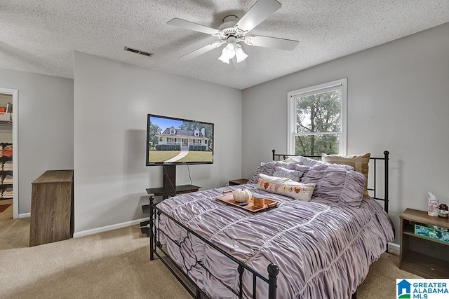 carpeted bedroom featuring a textured ceiling and ceiling fan