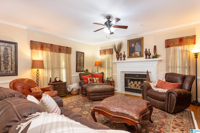 living room featuring ceiling fan, hardwood / wood-style flooring, a fireplace, and ornamental molding