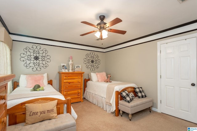 carpeted bedroom with ornamental molding and ceiling fan