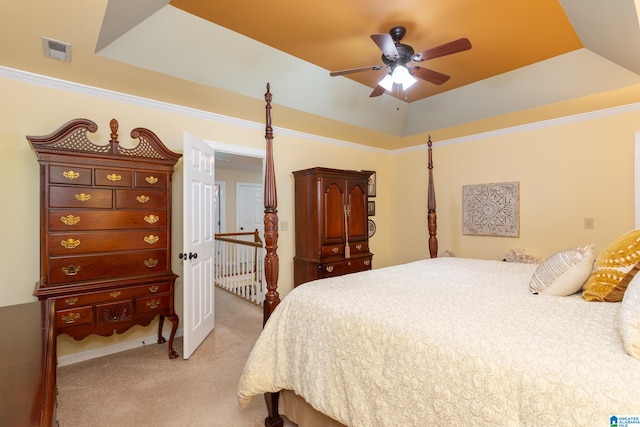 carpeted bedroom featuring ceiling fan and a tray ceiling