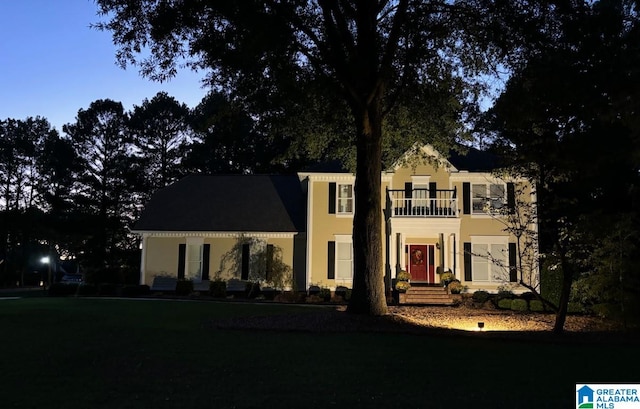 colonial-style house with stucco siding and a balcony