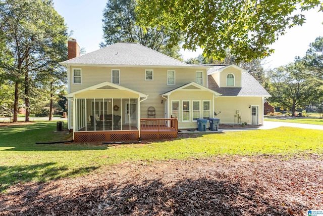 rear view of property with a yard and a sunroom