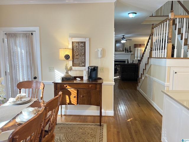 interior space featuring wood finished floors, a fireplace, a ceiling fan, and stairway
