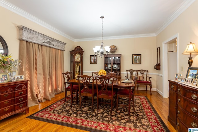 dining area featuring an inviting chandelier, hardwood / wood-style floors, and crown molding