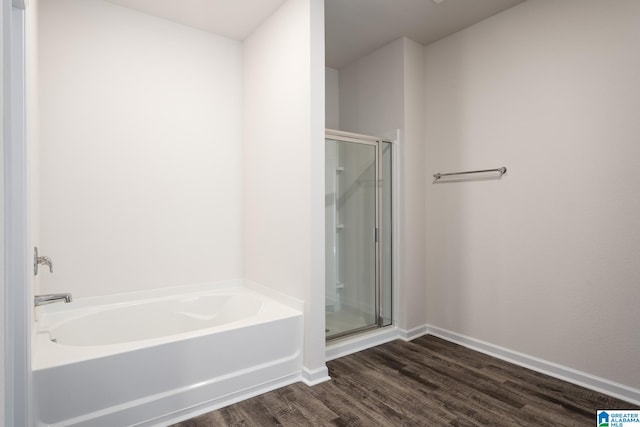 bathroom featuring wood-type flooring and shower with separate bathtub