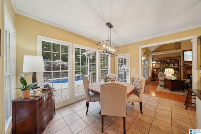 dining area featuring light wood-type flooring, crown molding, and a chandelier