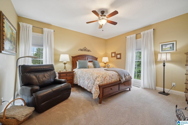 bedroom featuring multiple windows, ceiling fan, and carpet floors