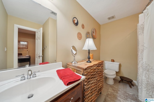 bathroom with vanity, tile patterned flooring, and toilet