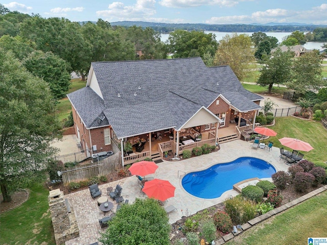 view of swimming pool with a yard, a patio, and a deck with water view