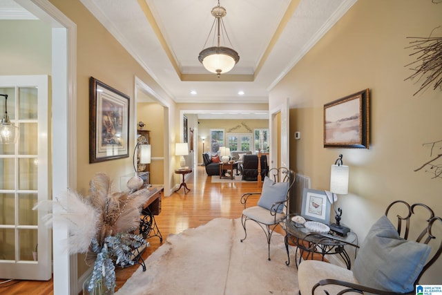 interior space featuring light wood-type flooring, ornamental molding, and a tray ceiling