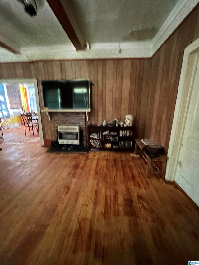 living room with a brick fireplace, heating unit, hardwood / wood-style flooring, and wooden walls