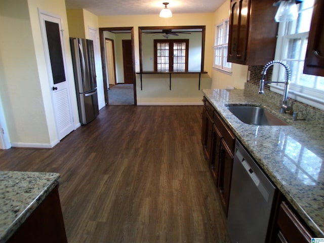 kitchen featuring a sink, baseboards, appliances with stainless steel finishes, and plenty of natural light