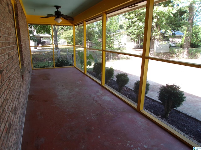 unfurnished sunroom with a ceiling fan and plenty of natural light