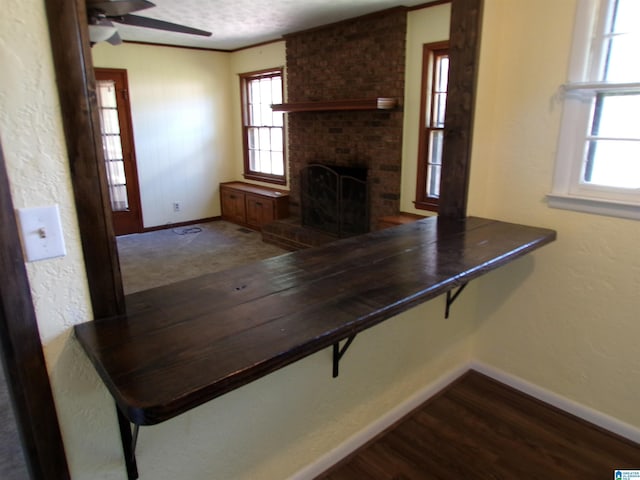 interior space featuring a brick fireplace, baseboards, and plenty of natural light