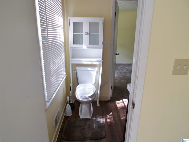bathroom featuring visible vents, toilet, wood finished floors, and baseboards