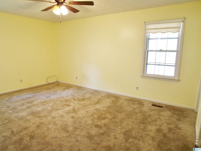 unfurnished room with visible vents, baseboards, a ceiling fan, and carpet flooring
