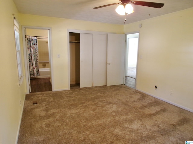 unfurnished bedroom with carpet floors, a ceiling fan, a closet, and ensuite bathroom