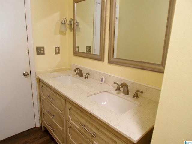 bathroom featuring double vanity, a sink, and wood finished floors