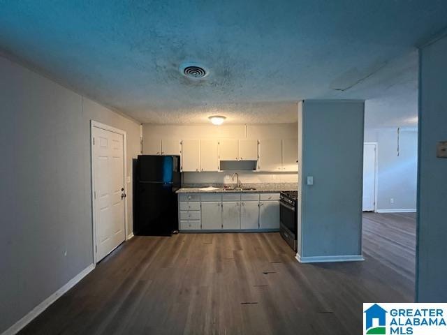 kitchen with a textured ceiling, dark wood-type flooring, sink, white cabinetry, and black appliances