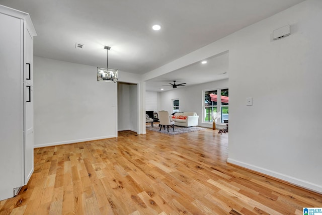 dining area featuring light hardwood / wood-style flooring and ceiling fan with notable chandelier