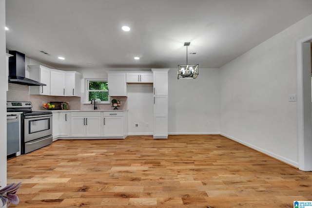 kitchen featuring wall chimney exhaust hood, white cabinetry, light hardwood / wood-style flooring, and electric range