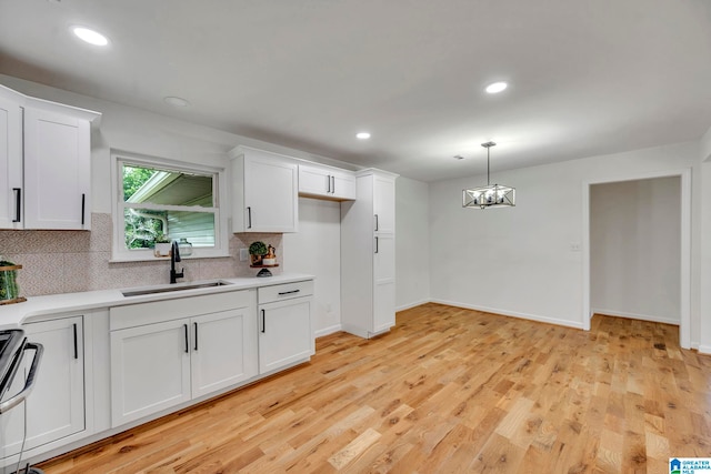 kitchen featuring light hardwood / wood-style floors, white cabinetry, sink, and tasteful backsplash