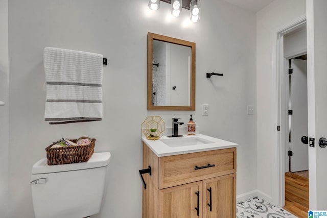 bathroom with wood-type flooring, vanity, and toilet