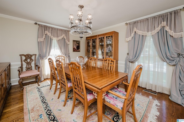 dining space featuring a notable chandelier, dark hardwood / wood-style floors, and crown molding