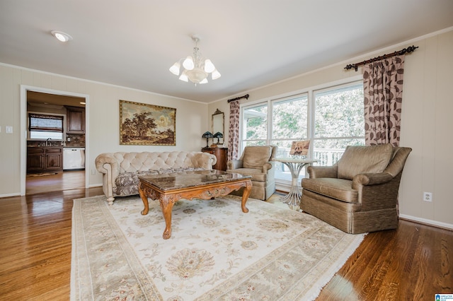 living room with ornamental molding, dark wood-type flooring, and a notable chandelier