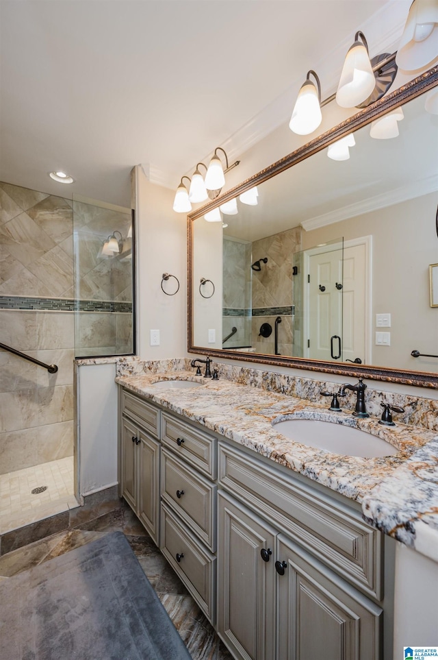 bathroom with a tile shower, vanity, and crown molding