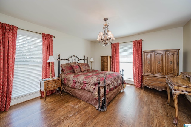 bedroom with a notable chandelier, hardwood / wood-style floors, and multiple windows