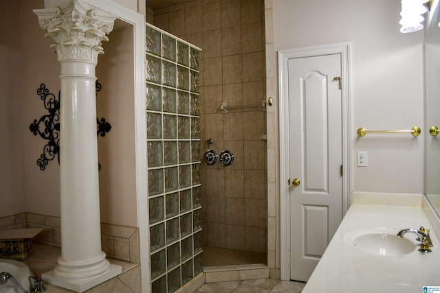 bathroom with vanity, ornate columns, tiled shower, and tile patterned flooring