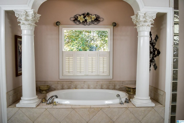 bathroom with decorative columns and tiled bath