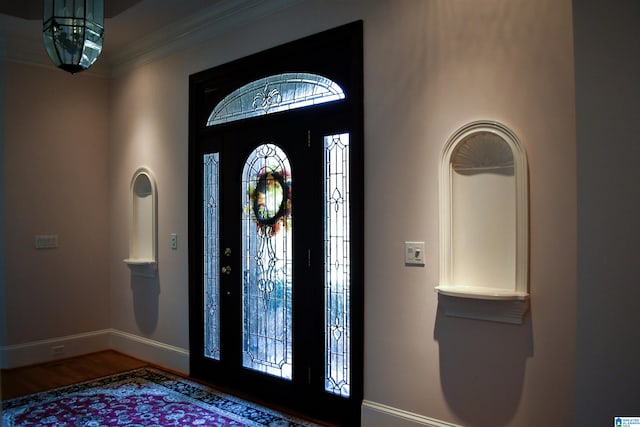 foyer with ornamental molding and hardwood / wood-style floors