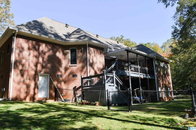 back of property with a sunroom and a lawn