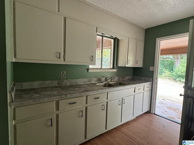 kitchen featuring light hardwood / wood-style flooring, a textured ceiling, a healthy amount of sunlight, and sink