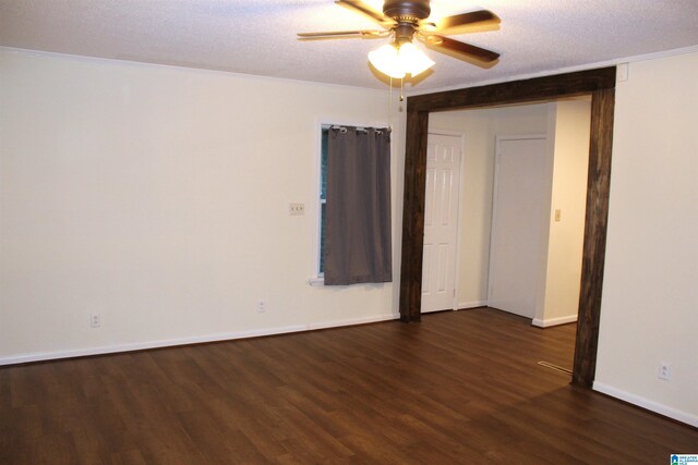 empty room with ceiling fan, dark wood-type flooring, and a textured ceiling