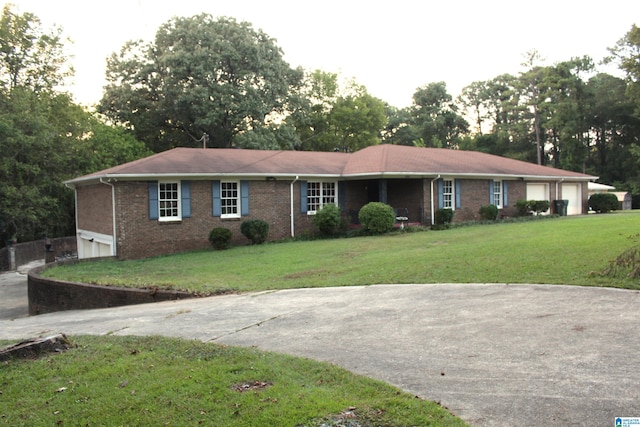 ranch-style house featuring a garage and a front yard