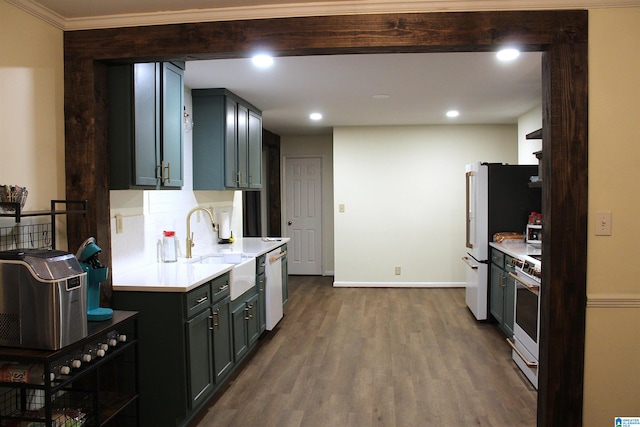 kitchen featuring backsplash, white appliances, dark hardwood / wood-style flooring, ornamental molding, and sink