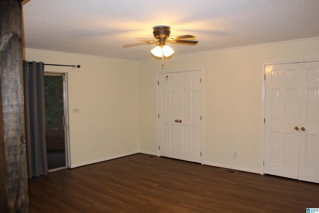 unfurnished bedroom with a textured ceiling, ceiling fan, crown molding, and dark hardwood / wood-style flooring