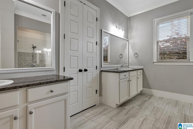 bathroom featuring tiled shower and vanity